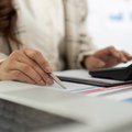 Accountant reviewing financial reports with a calculator during accounting and finance planning