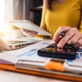 Woman at desk using calculator
