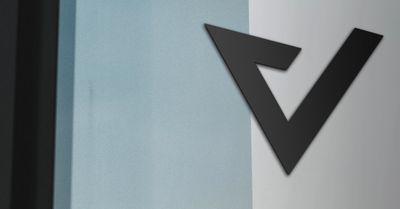 Capovario logo submark in black on an office wall