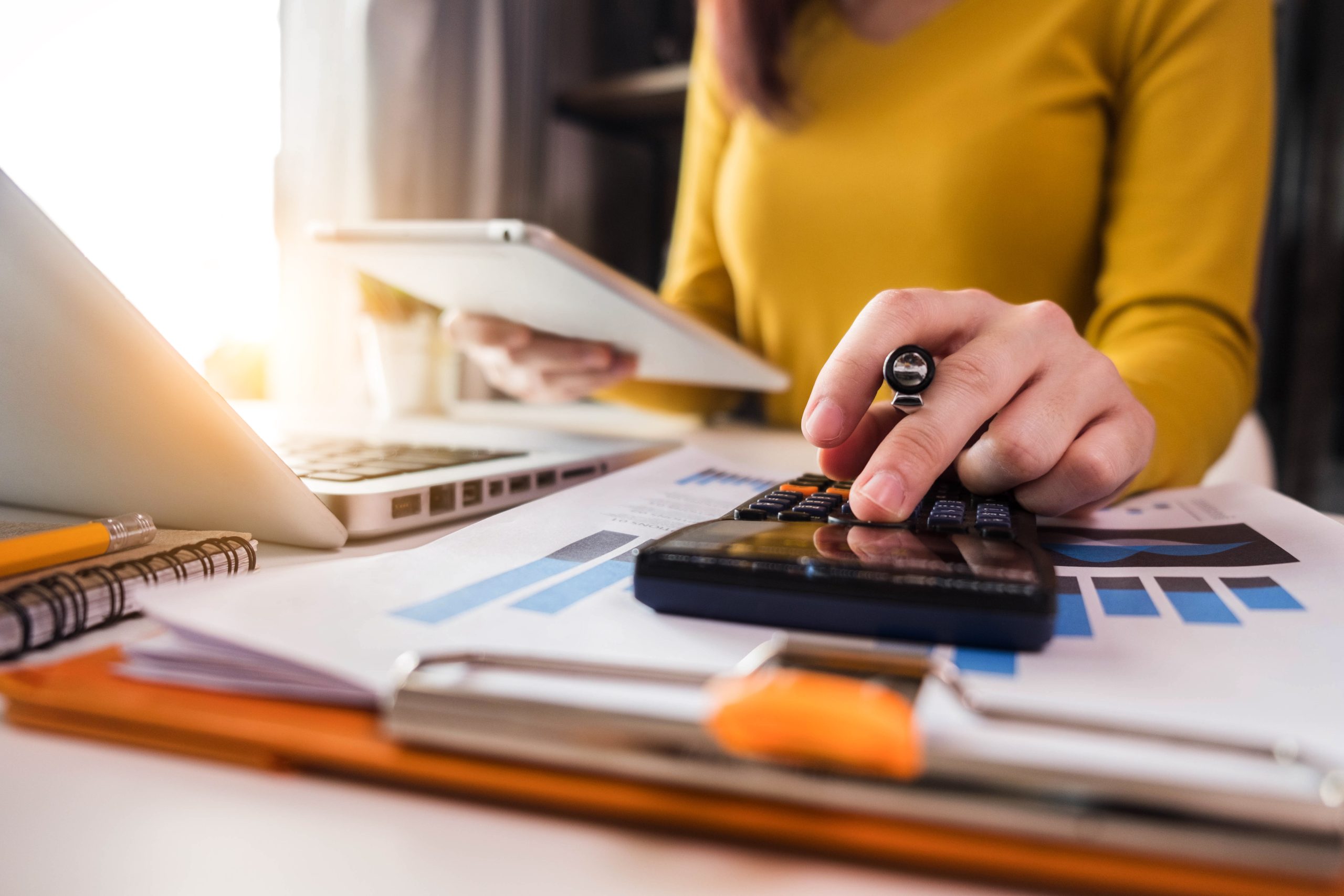 Woman at desk using calculator
