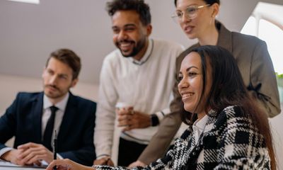 Four young business entrepreneurs facing to the left and smiling